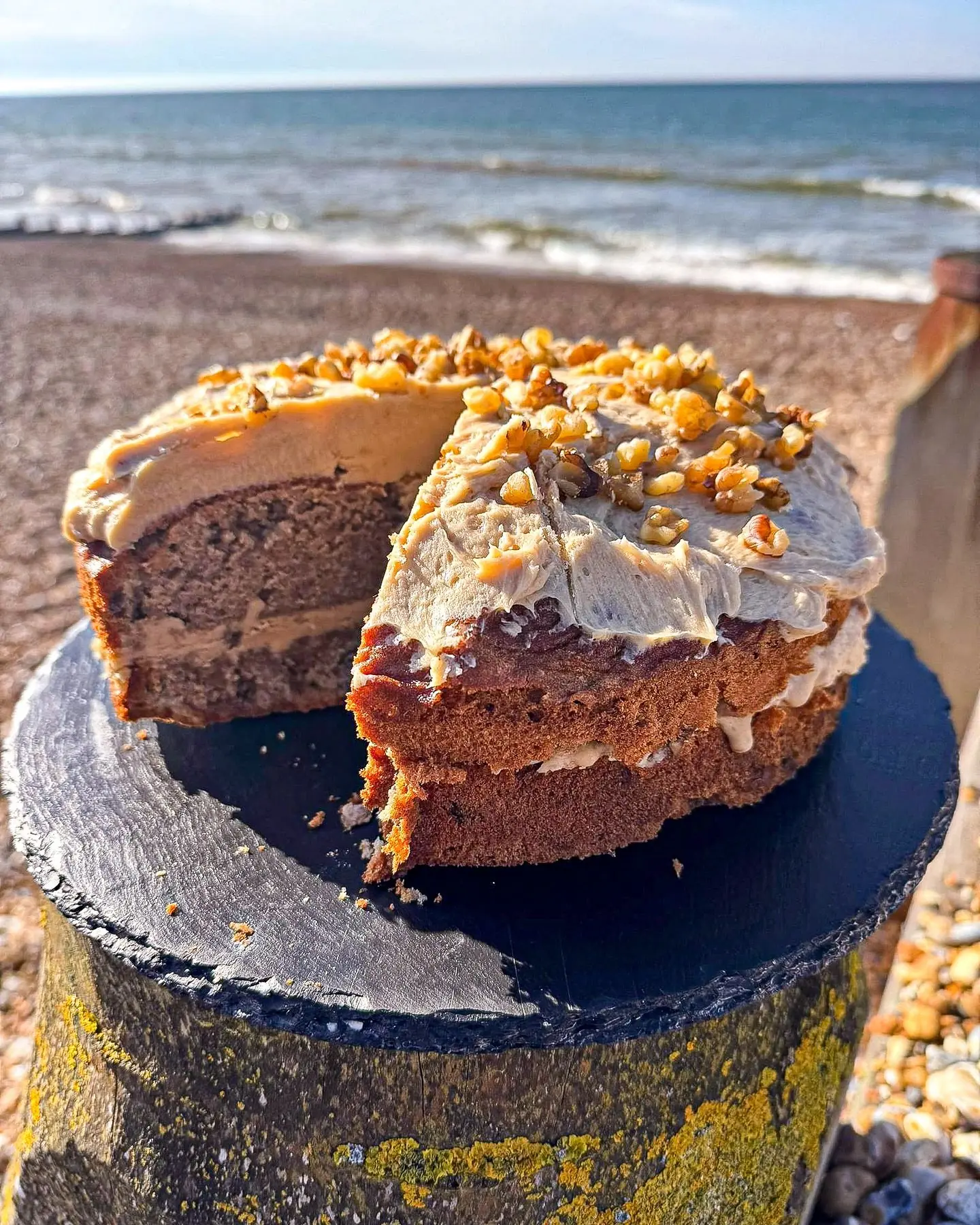 A coffee and walnut cake on a post by the sea