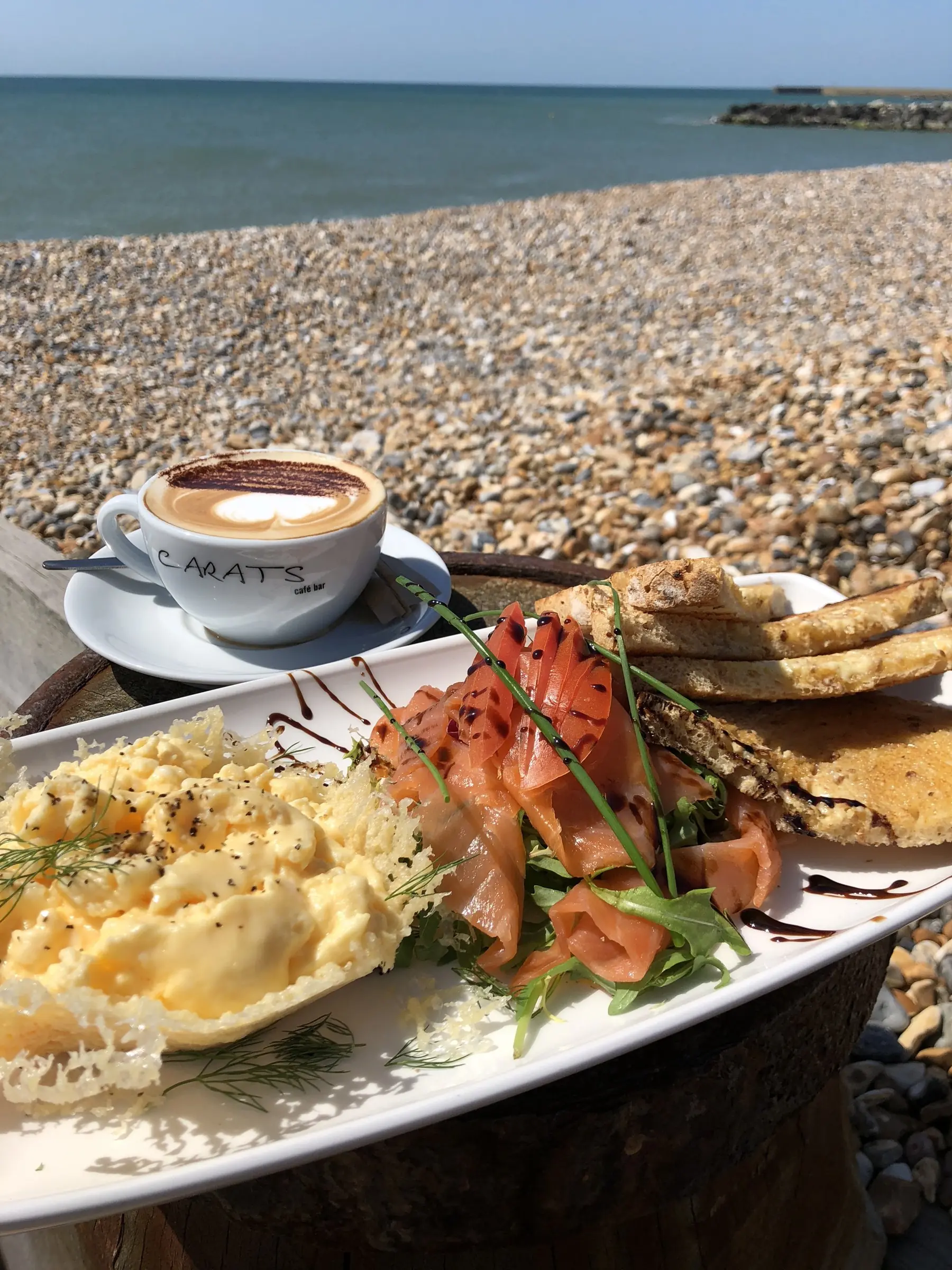 Scrambled eggs, smoked salmon and a cappuccino on the beach