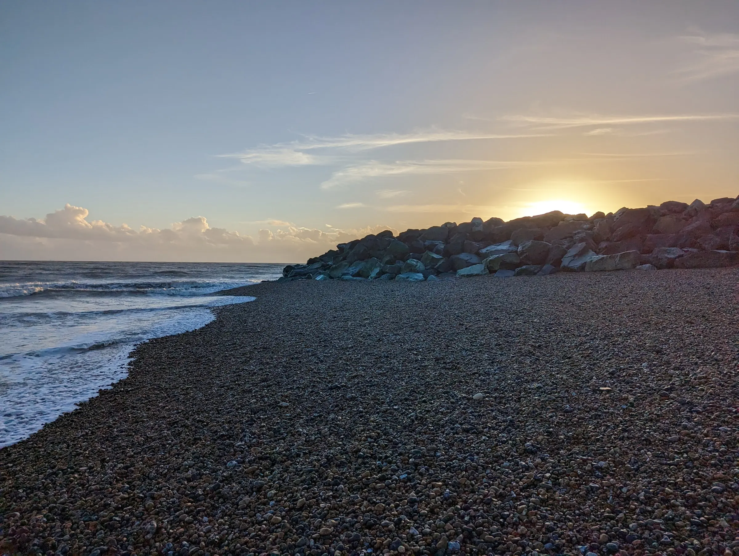 Sunset over the shingle and breakwater at Southwick beach